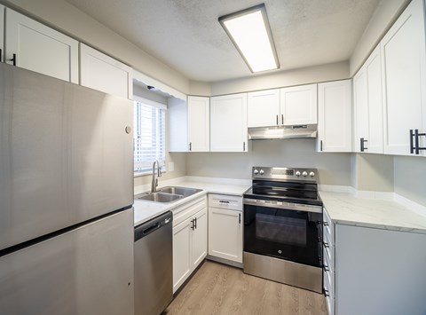 A modern kitchen with stainless steel appliances and white cabinets.