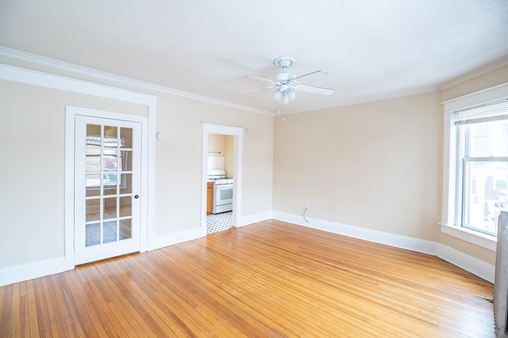 A room with a wooden floor and a ceiling fan.