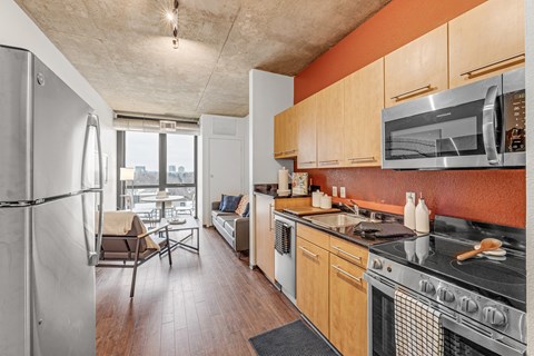 A kitchen with a refrigerator, oven, and microwave.