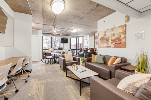 A modern office space with a couch, chairs, and a television.