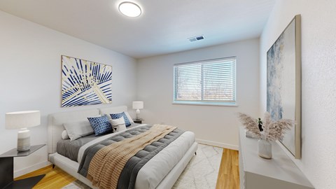 A bedroom with a large bed and a painting on the wall.