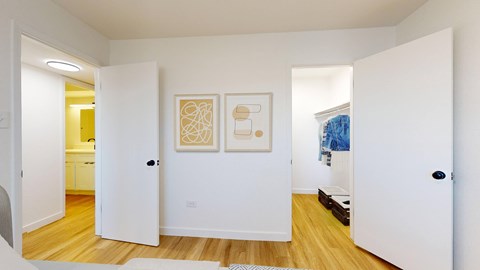 A hallway with two doors open to a kitchen and a bathroom.