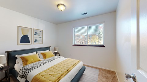 A bedroom with a bed, nightstand, and window.