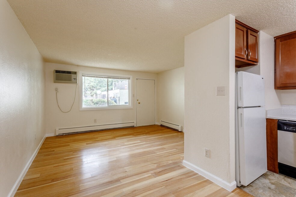 an empty kitchen with a refrigerator and a window