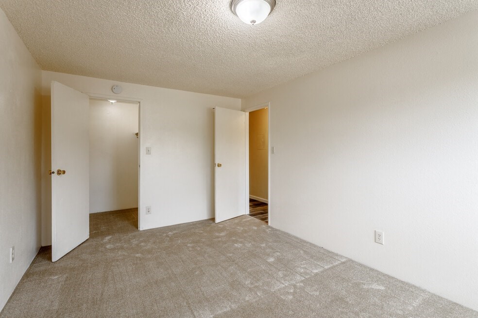 the spacious living room and dining room of an apartment
