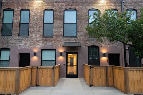 A building with a brown brick facade and a wooden fence in front.