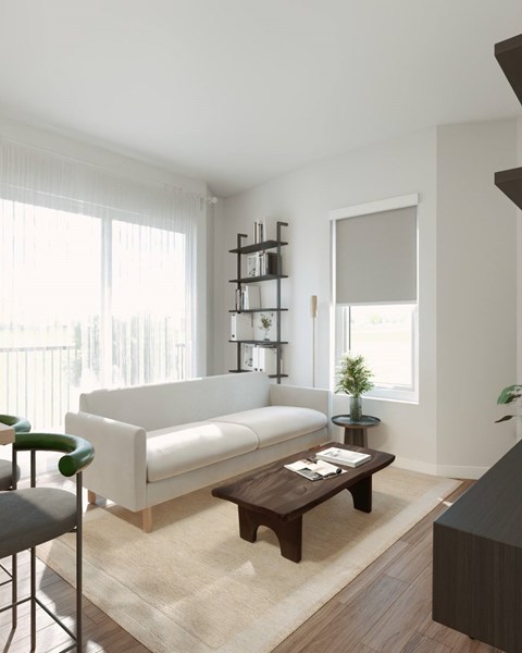 A white sofa sits in a living room with a wooden coffee table in front of it.