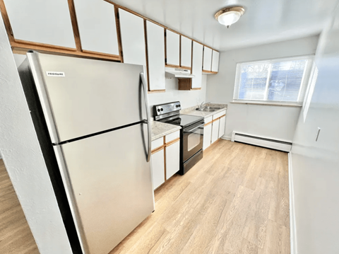 A kitchen with a refrigerator, oven, and microwave.
