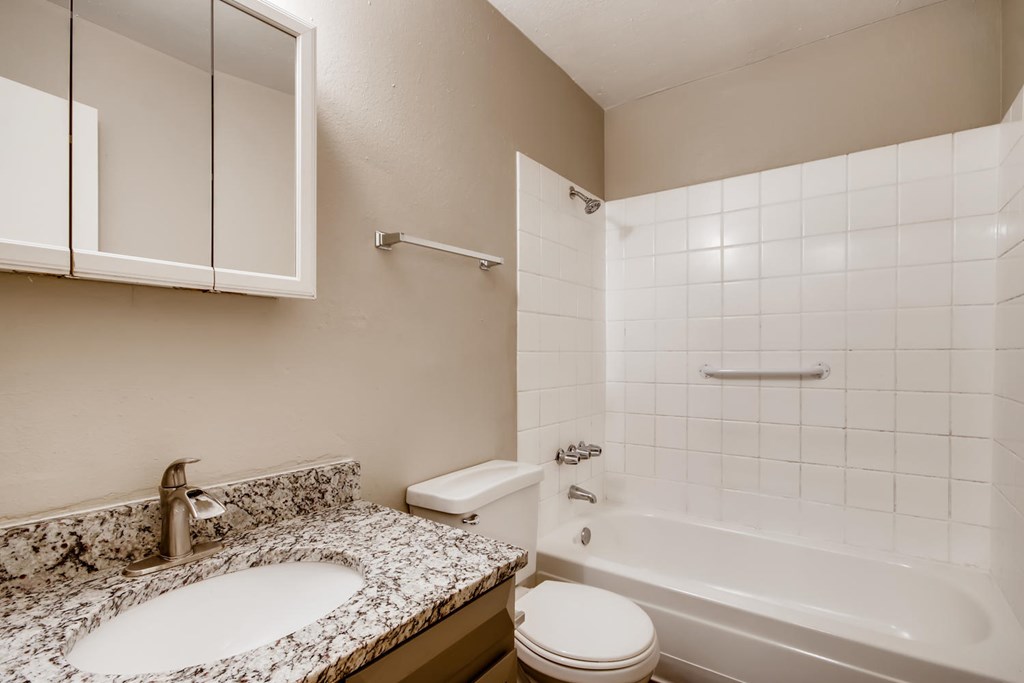 A bathroom with a sink, toilet, and bathtub.