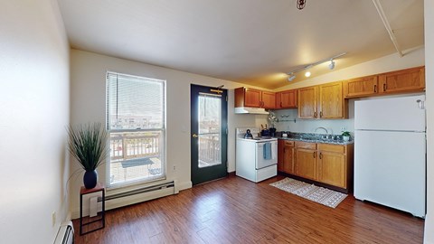 A kitchen with wooden floors and white appliances.