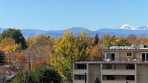 the view of the snow capped mountains from the roof of a building