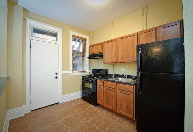 a kitchen with a black refrigerator and a sink