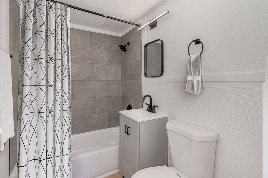 a bathroom with a shower and a toilet and a shower curtain