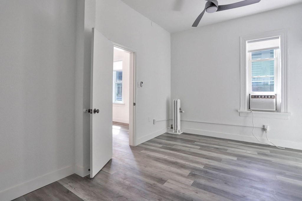 an empty living room with white walls and wood floors