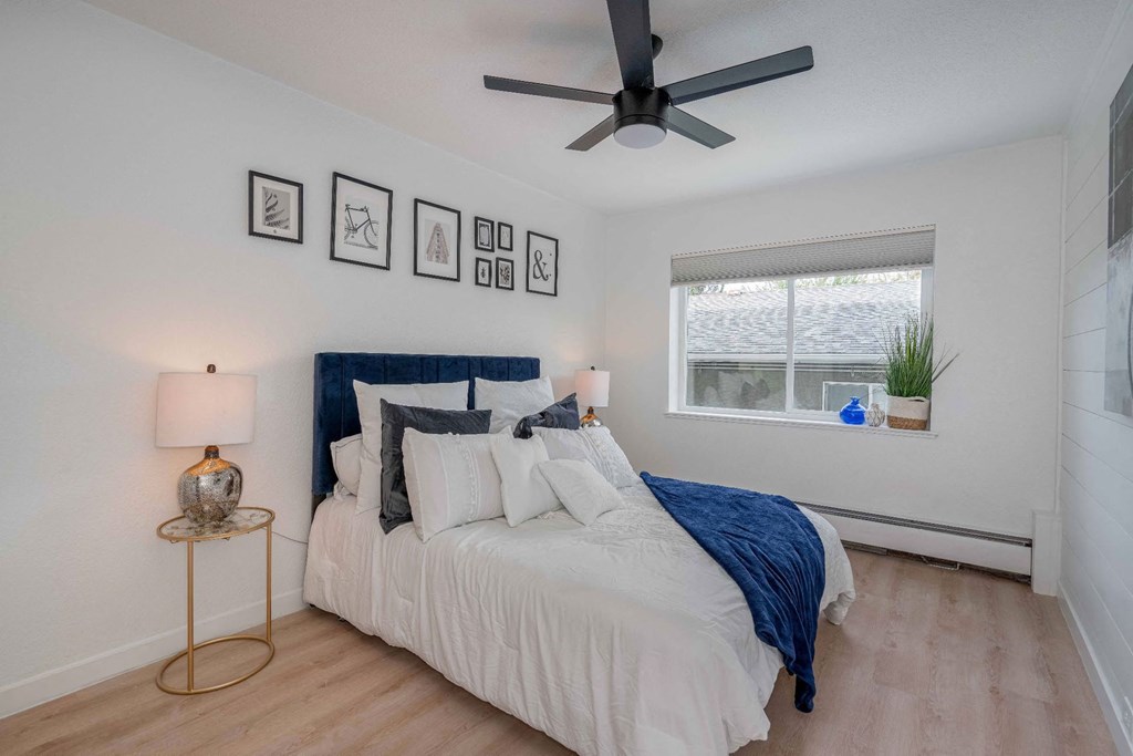 a bedroom with a bed and a ceiling fan