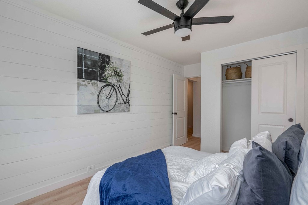 a bedroom with a bed and a ceiling fan