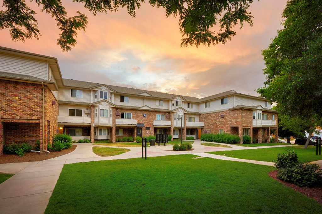 Apartment complex with a grassy area in front.