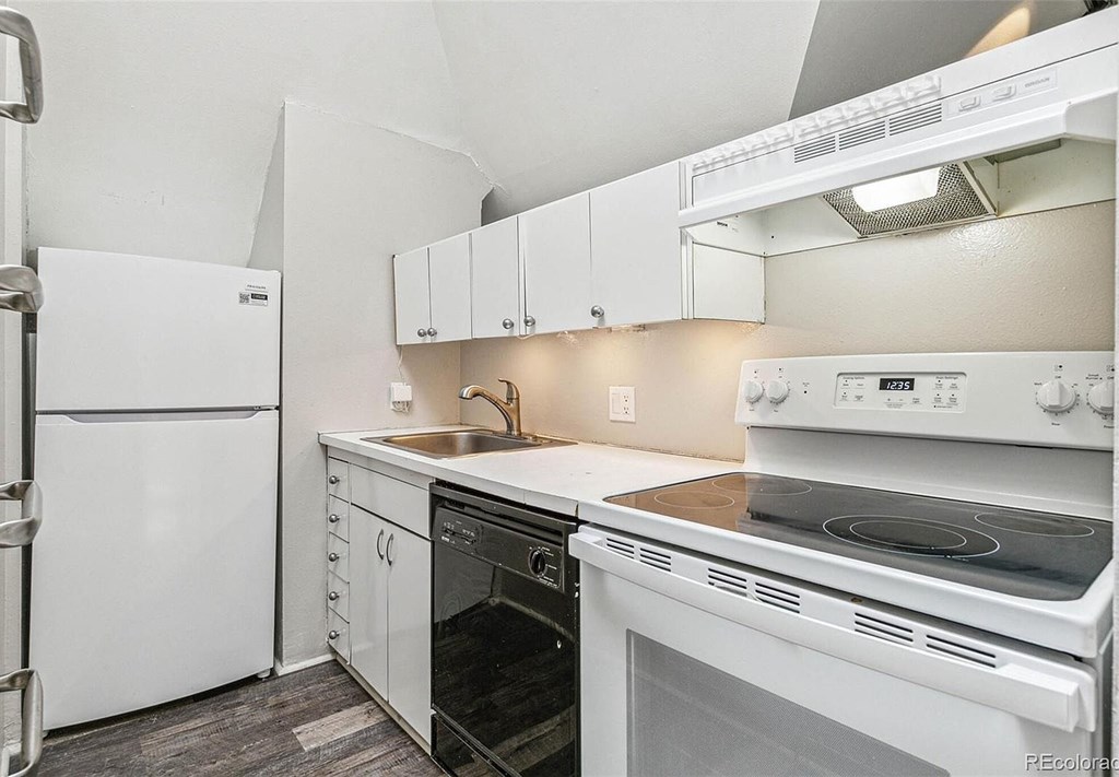 A white kitchen with a stove, oven, and refrigerator.