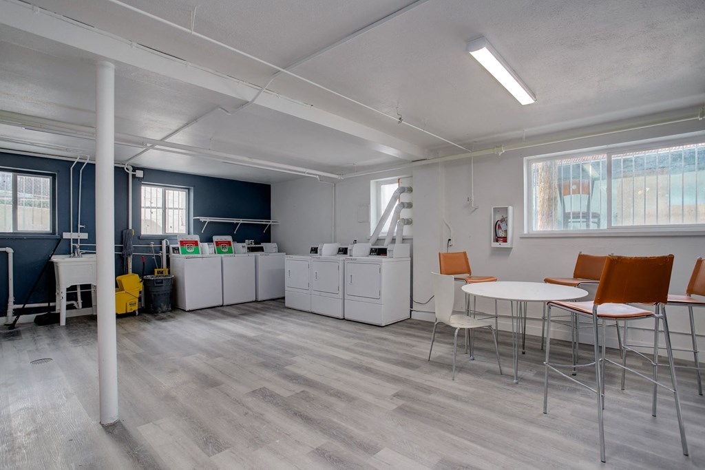 a break room with tables and chairs and a kitchen
