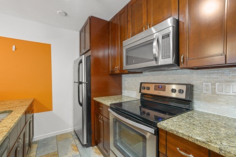 A kitchen with a stove top oven and a microwave above it.