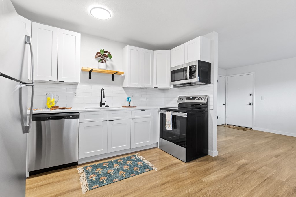 A kitchen with white cabinets and a black oven.