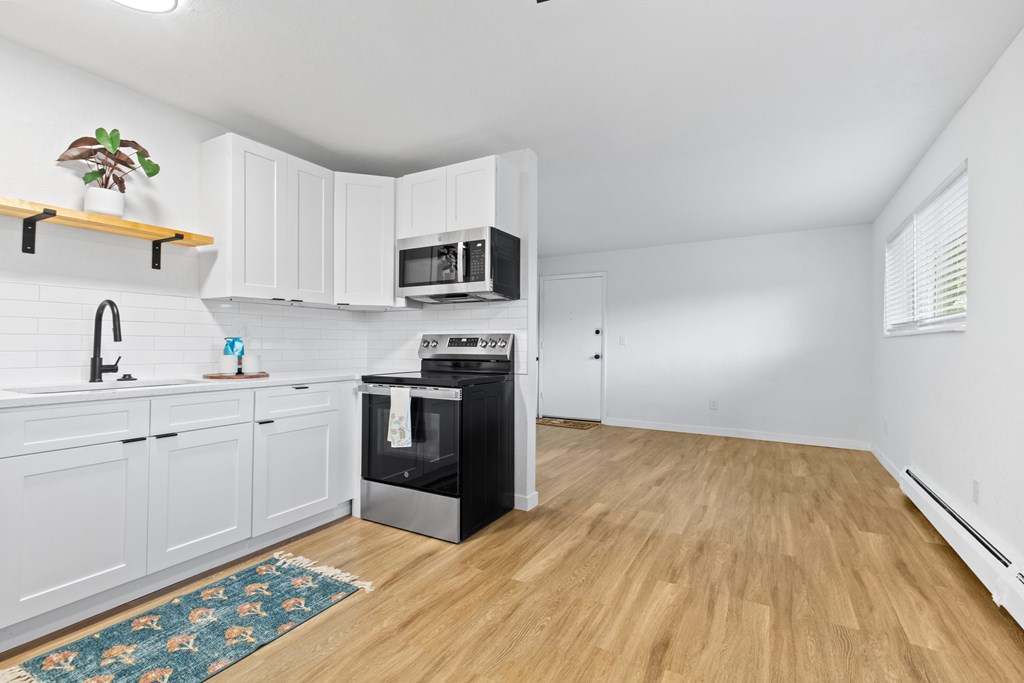 A kitchen with white cabinets and a black oven.