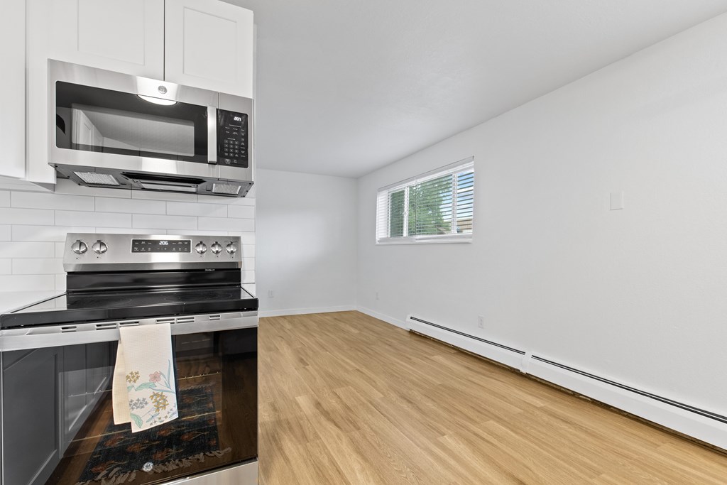 A kitchen with a stove, oven, and microwave.