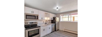 A kitchen with white cabinets and a black stove top oven.