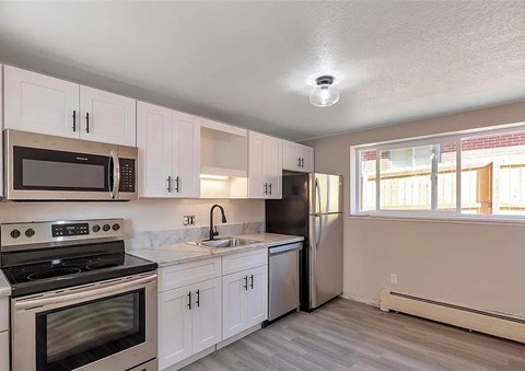 A kitchen with white cabinets and a black stove top oven.