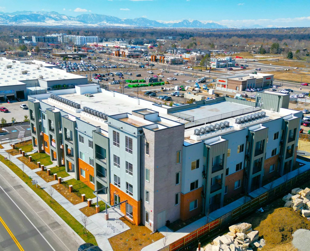 A view of a town with apartment buildings and a parking lot.