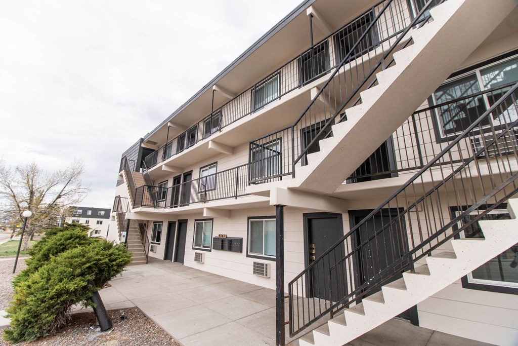 the exterior of an apartment building with stairs and a courtyard
