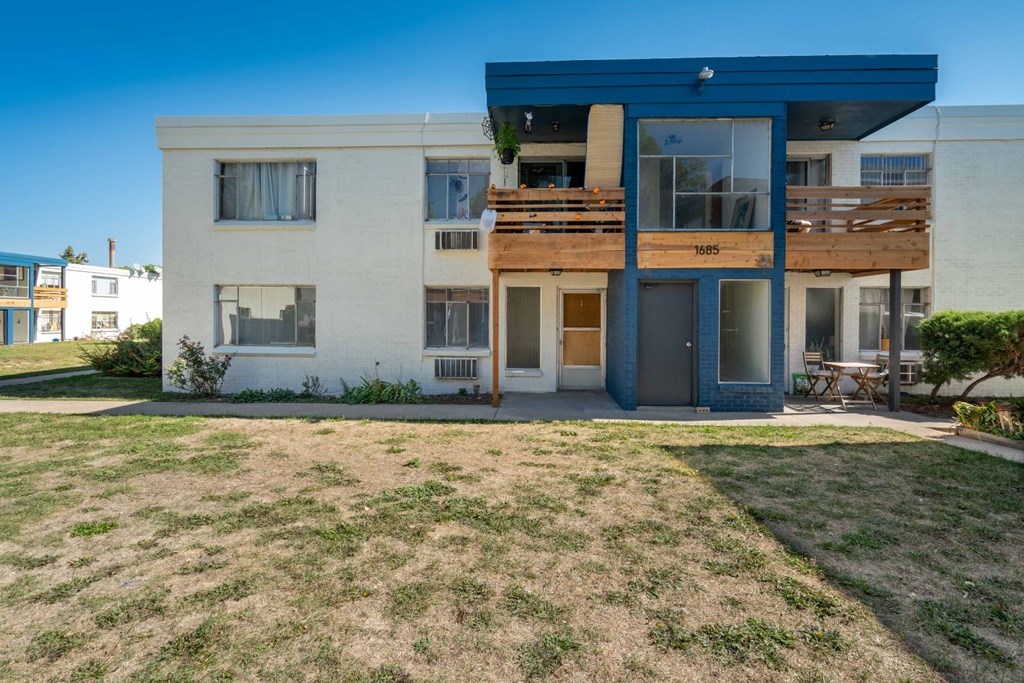 the back of a house with a yard and a balcony