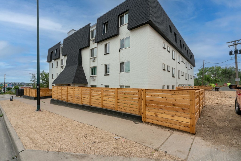 a wooden fence in front of an apartment building