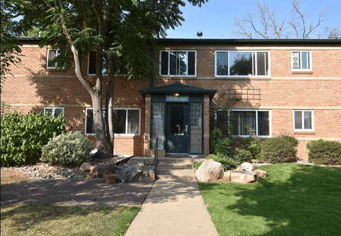 the front of a brick house with a sidewalk in front of it