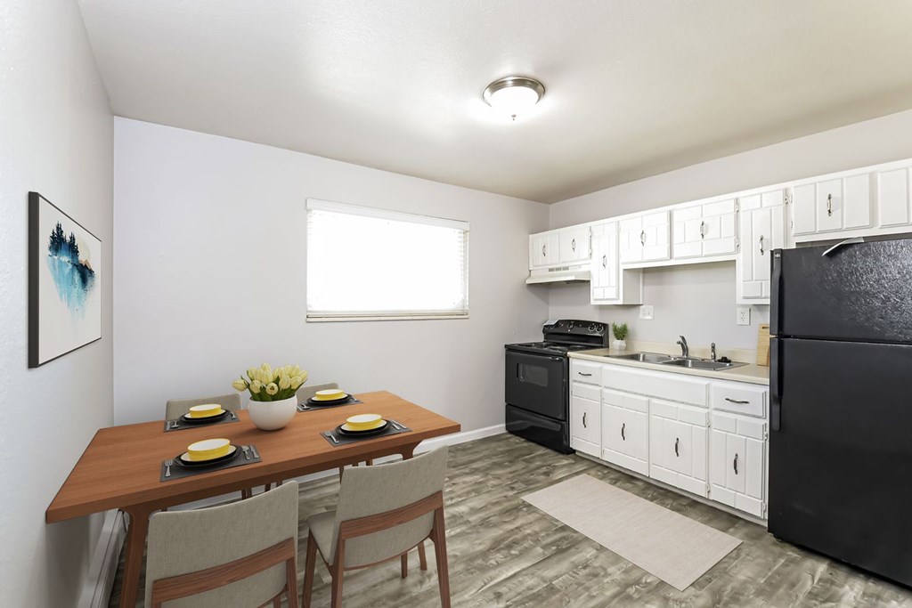 A kitchen with black appliances and white cabinets.