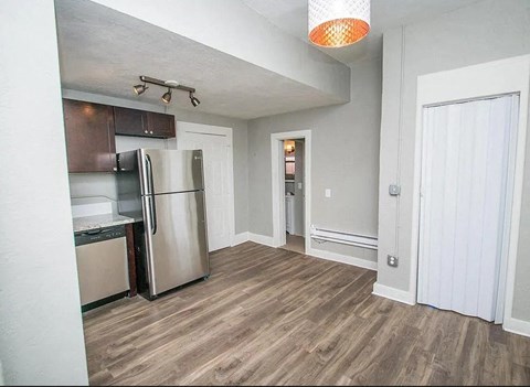 A kitchen with a refrigerator, microwave, and oven.