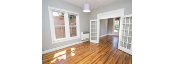 A room with a wood floor and a window.