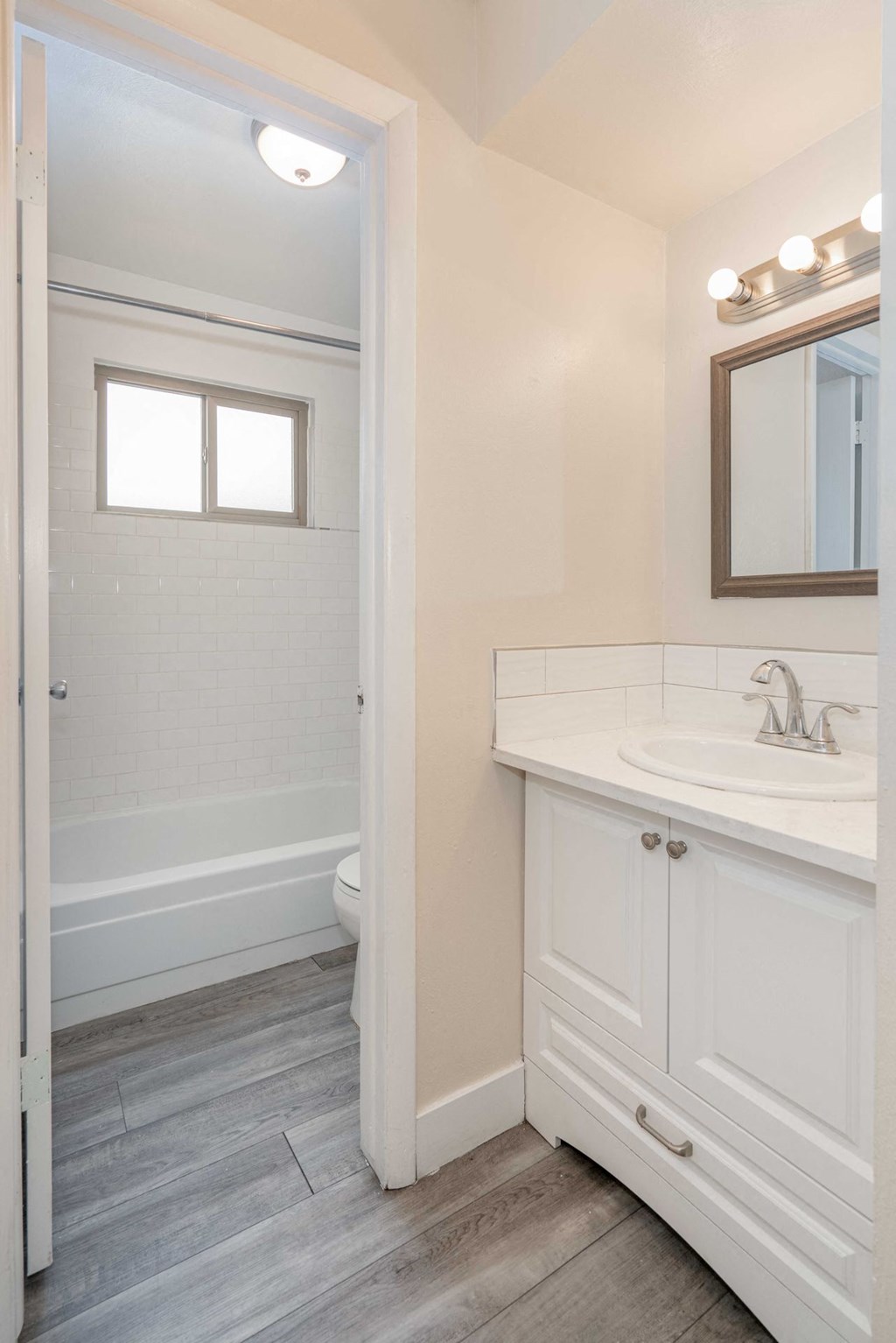 a bathroom with white cabinets and a sink and a toilet