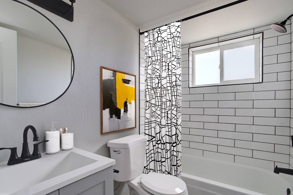 a white bathroom with a shower curtain and a toilet and a sink