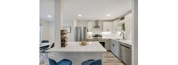 a white counter and a stainless steel refrigerator at The Iris Apartments, Arvada, Colorado