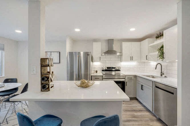 a kitchen with a white counter and a stainless steel refrigerator at The Iris Apartments, Arvada, Colorado