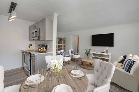 A modern dining room with a wooden table set for two.