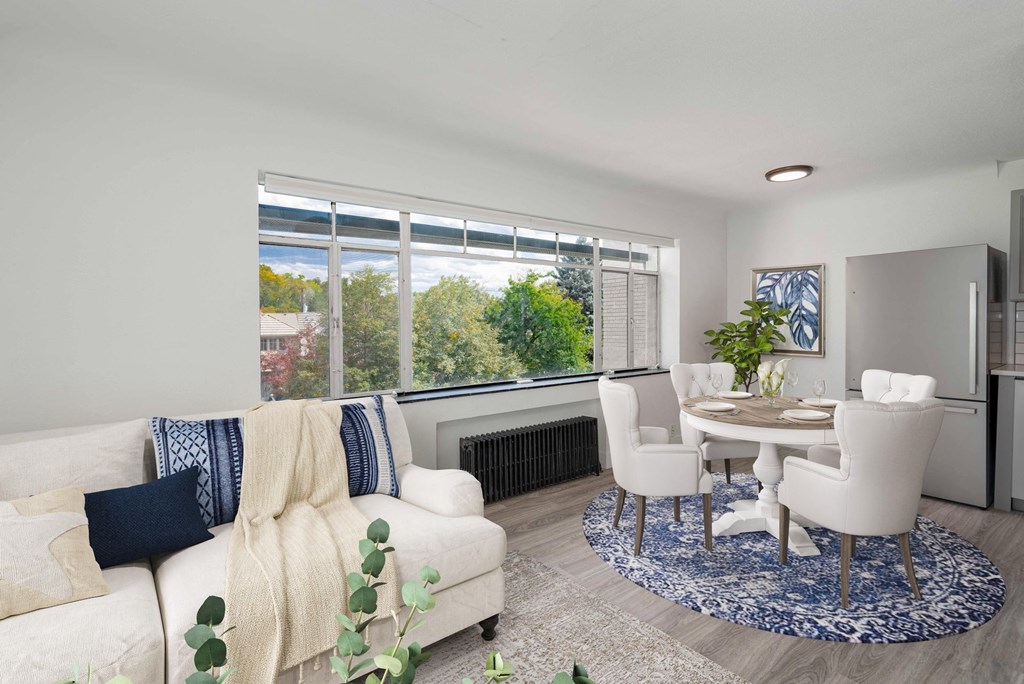 a living room with white furniture and a large window