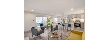 a living room and kitchen with a table and chairs at The Iris Apartments, Arvada, CO