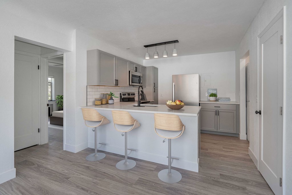 a kitchen with a bar and stools in a house