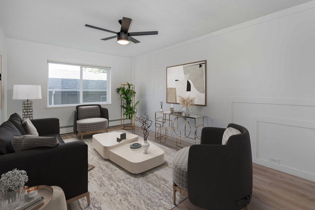 a living room with black furniture and a ceiling fan