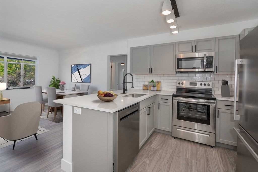 a kitchen with stainless steel appliances and a white counter top