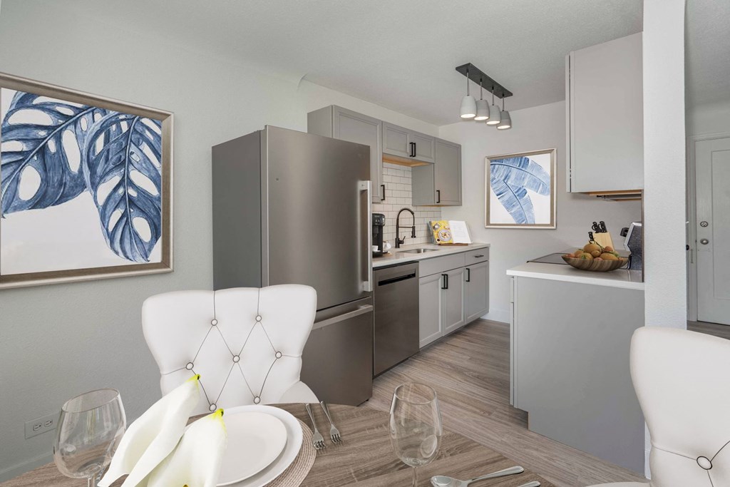 a kitchen and dining room with stainless steel appliances and a table and chairs