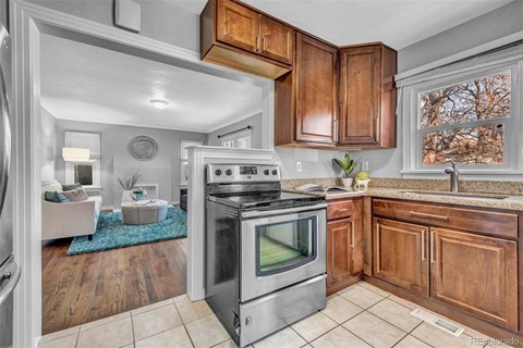A kitchen with a stove top oven and wooden cabinets.