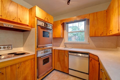 a kitchen with wooden cabinets and stainless steel appliances
